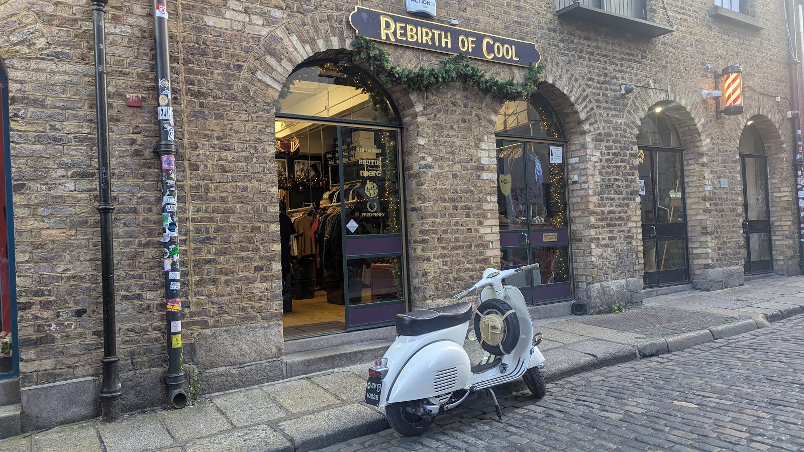 Shopfront on Temple Lane South, Temple Bar — cobblestones, barber pole and a scooter outside The Granary